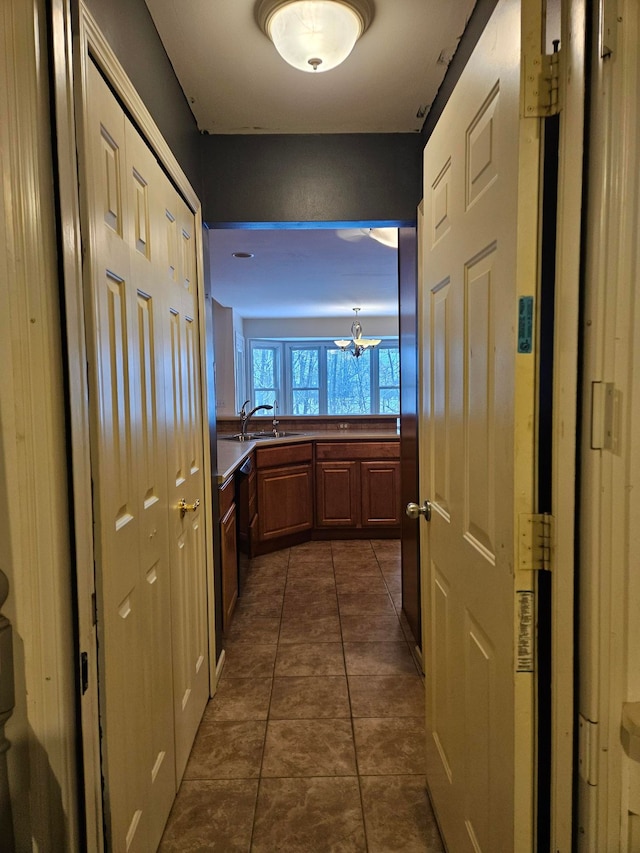 hallway featuring dark tile patterned floors and a sink