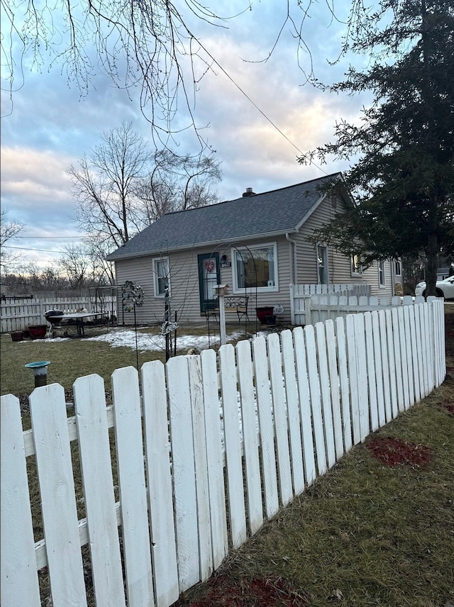 view of front of property featuring roof with shingles and a fenced front yard