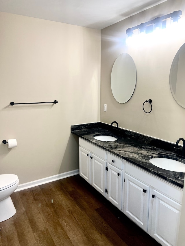 bathroom featuring toilet, vanity, and hardwood / wood-style floors