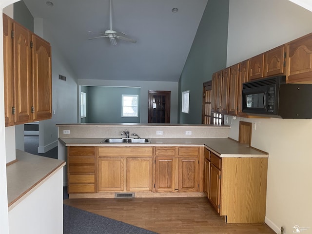 kitchen featuring ceiling fan, dark wood-type flooring, sink, and kitchen peninsula