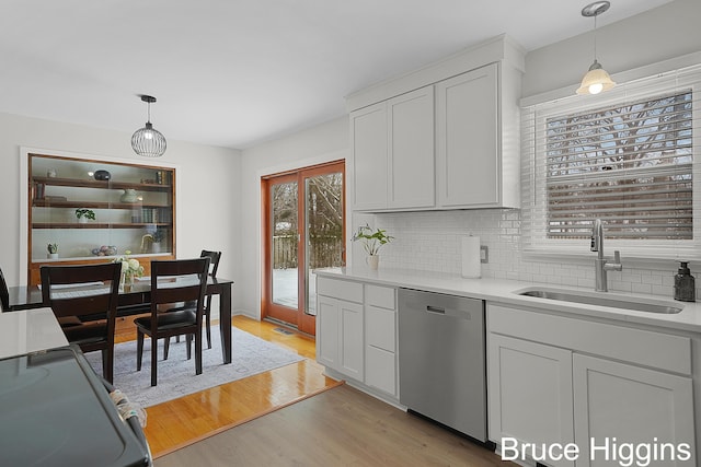 kitchen featuring light hardwood / wood-style flooring, dishwasher, pendant lighting, sink, and white cabinetry