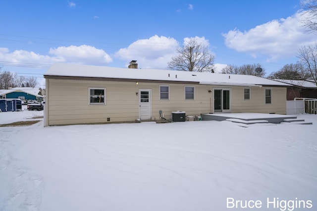 snow covered property with cooling unit