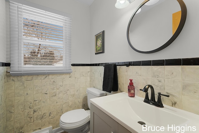 bathroom with tile walls, vanity, and toilet