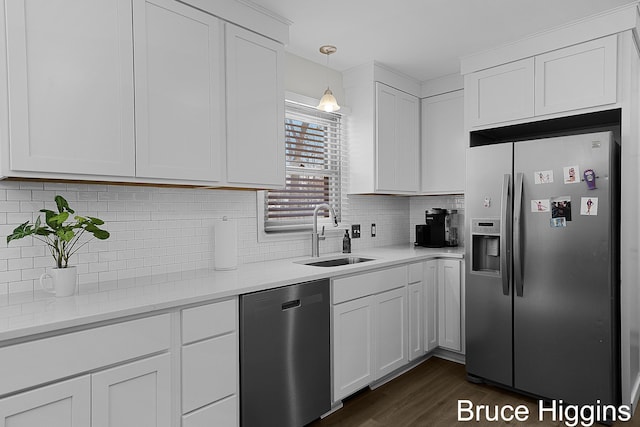 kitchen with appliances with stainless steel finishes, sink, white cabinetry, and pendant lighting