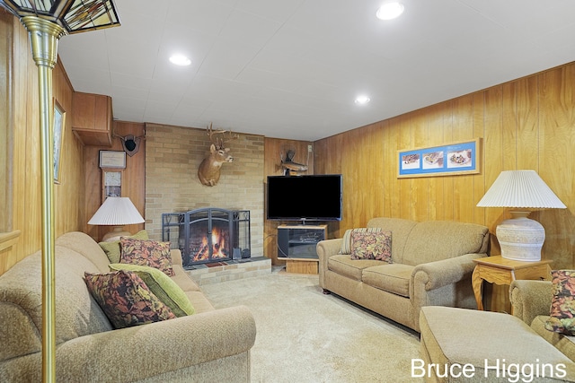 carpeted living room featuring a brick fireplace and wood walls