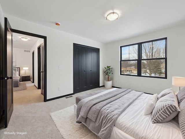 bedroom featuring light carpet, baseboards, visible vents, and a closet