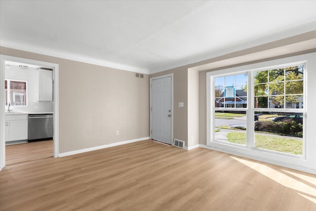 unfurnished living room with light hardwood / wood-style flooring and sink