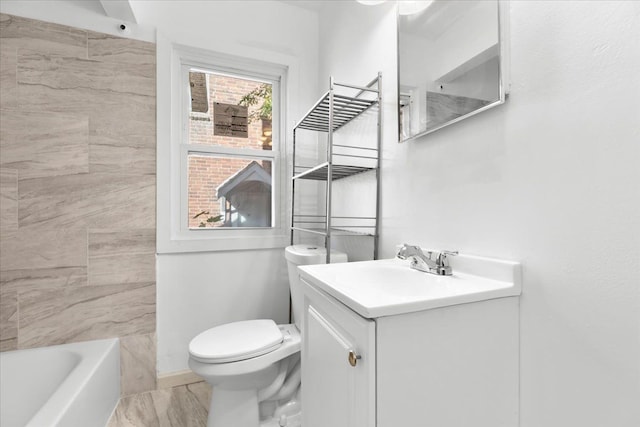 bathroom with toilet, vanity, and a bathing tub