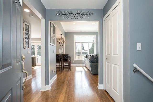 entryway featuring dark wood finished floors, an inviting chandelier, and baseboards