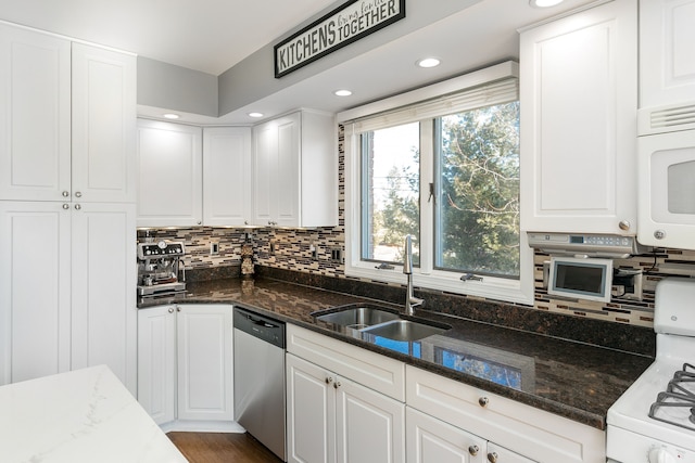 kitchen featuring white appliances, white cabinets, tasteful backsplash, and a sink