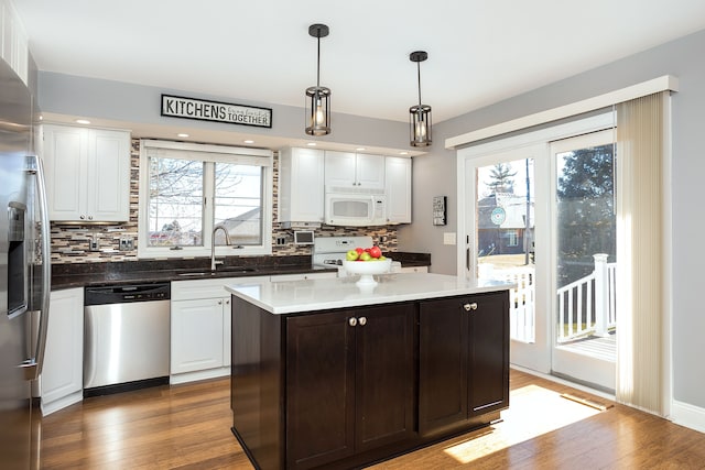 kitchen with white cabinetry, wood finished floors, appliances with stainless steel finishes, and a sink