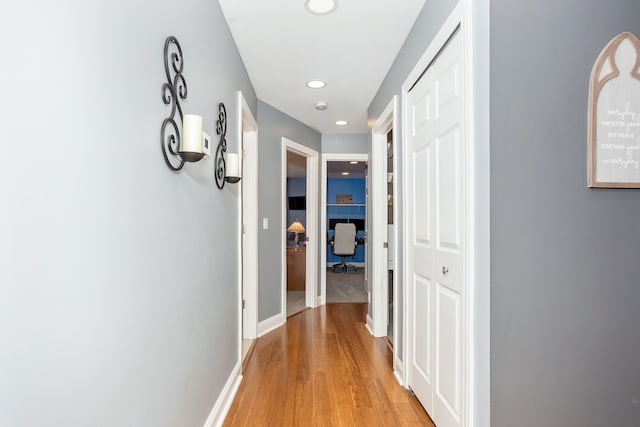 corridor featuring recessed lighting, baseboards, and light wood finished floors