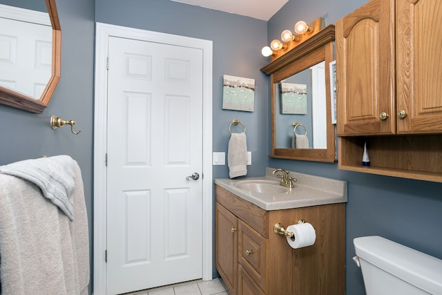 half bath featuring tile patterned flooring, toilet, and vanity