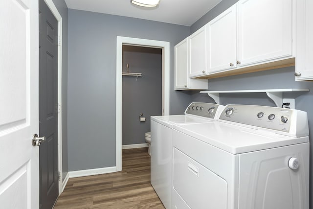 laundry area featuring washer and clothes dryer, cabinet space, baseboards, and wood finished floors