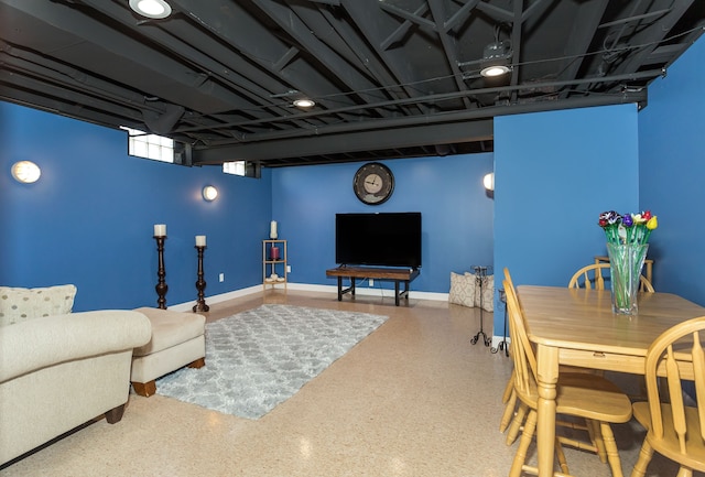 living area with speckled floor and baseboards