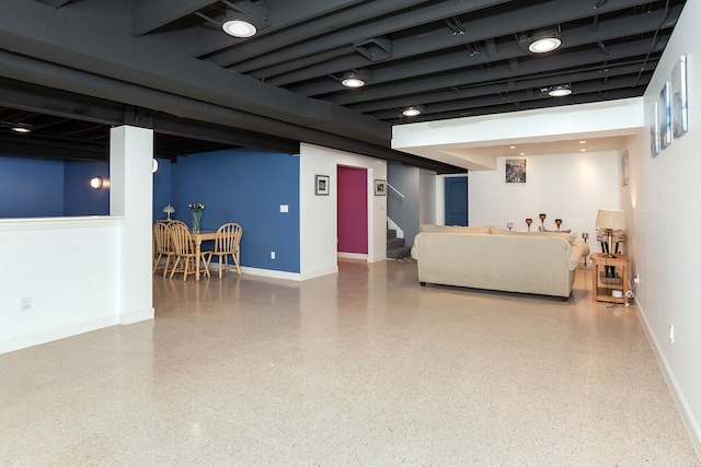 living room with stairway, speckled floor, and baseboards