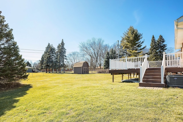 view of yard featuring stairway, central AC unit, a storage shed, a deck, and an outbuilding