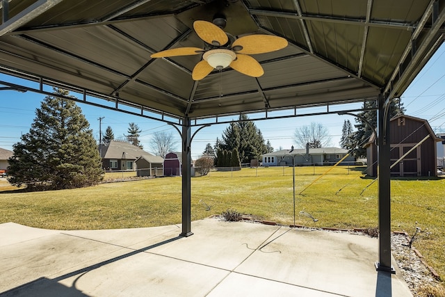 view of patio / terrace with a storage shed, an outdoor structure, a gazebo, and a ceiling fan