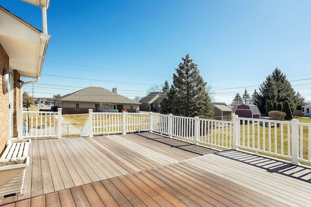 wooden deck with an outdoor structure and a yard