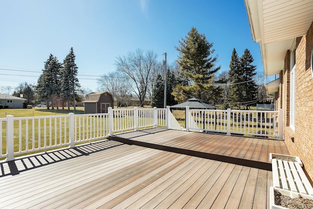 deck featuring a storage unit, an outbuilding, and a yard