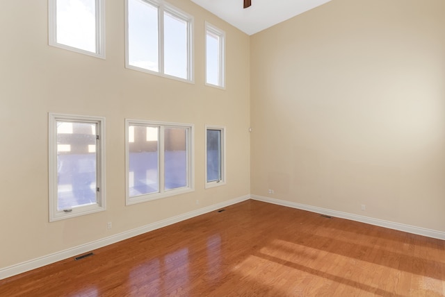 spare room with light wood-style floors, baseboards, and visible vents