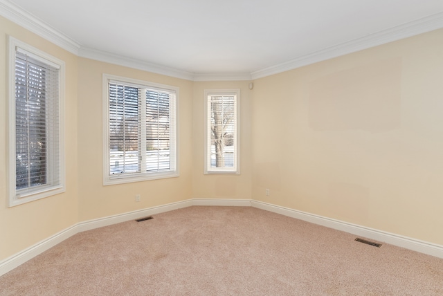 unfurnished room with ornamental molding, carpet flooring, visible vents, and baseboards