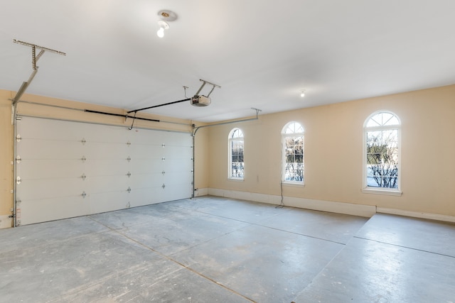 garage featuring a garage door opener and baseboards