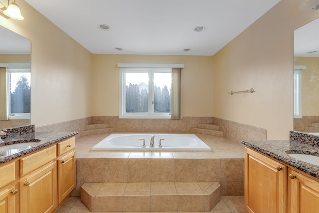 bathroom featuring a healthy amount of sunlight, two vanities, and a sink