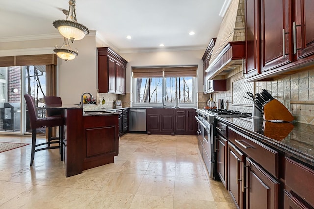 kitchen featuring a breakfast bar area, dark stone countertops, decorative light fixtures, stainless steel appliances, and a sink