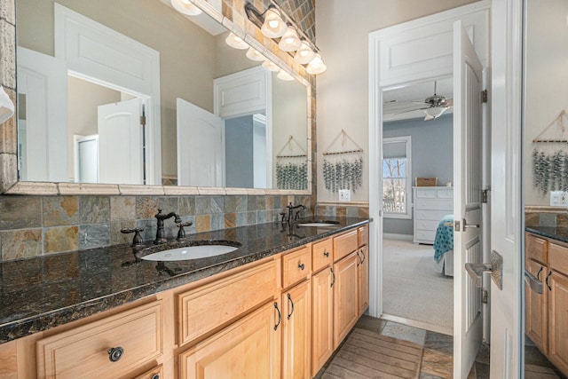 ensuite bathroom with double vanity, tasteful backsplash, a sink, and ensuite bathroom