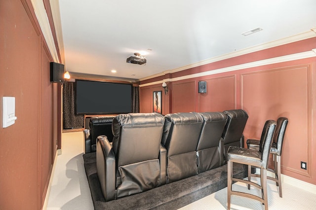 cinema featuring ornamental molding, visible vents, and light colored carpet