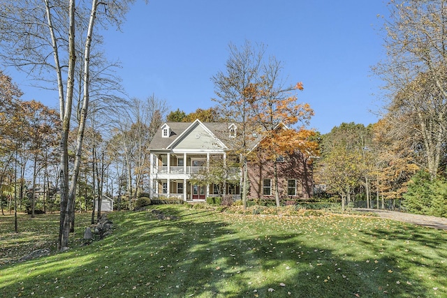 greek revival house with a front yard and a balcony