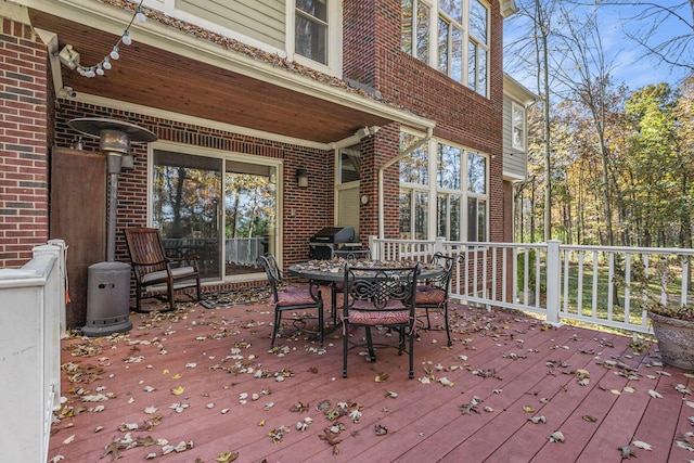 wooden terrace featuring outdoor dining space and a grill