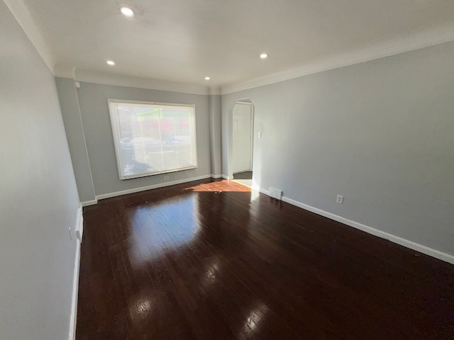 spare room with ornamental molding, recessed lighting, baseboards, and wood finished floors