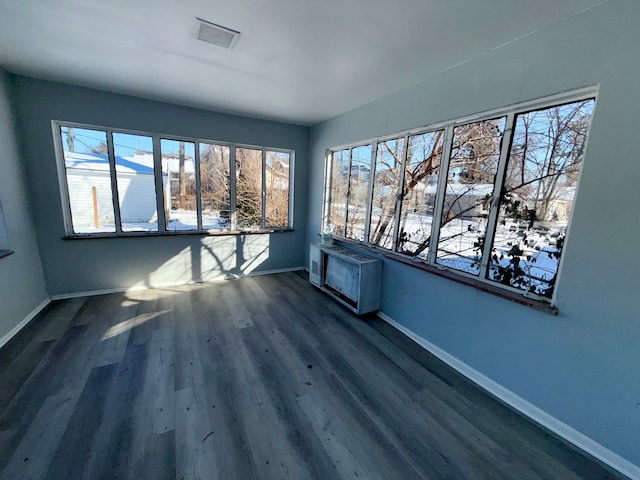 interior space with dark wood-style floors, plenty of natural light, and baseboards