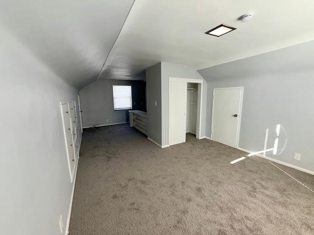 bonus room with lofted ceiling, baseboards, and carpet