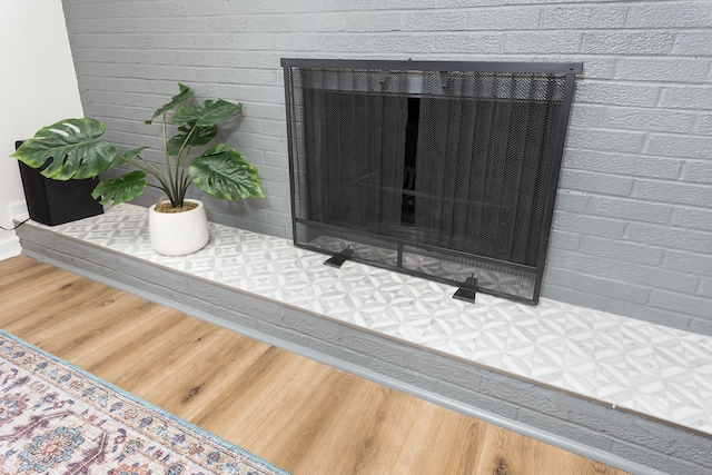 room details featuring a brick fireplace and wood finished floors