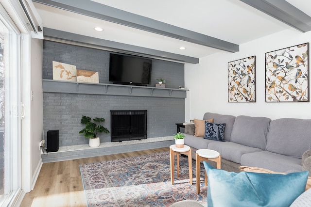 living area featuring recessed lighting, a fireplace, wood finished floors, baseboards, and beamed ceiling