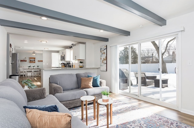 living room featuring recessed lighting, beam ceiling, and wood finished floors