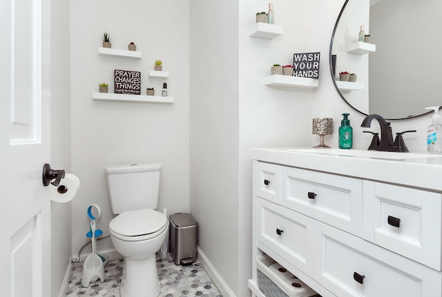 bathroom with toilet, baseboards, and vanity