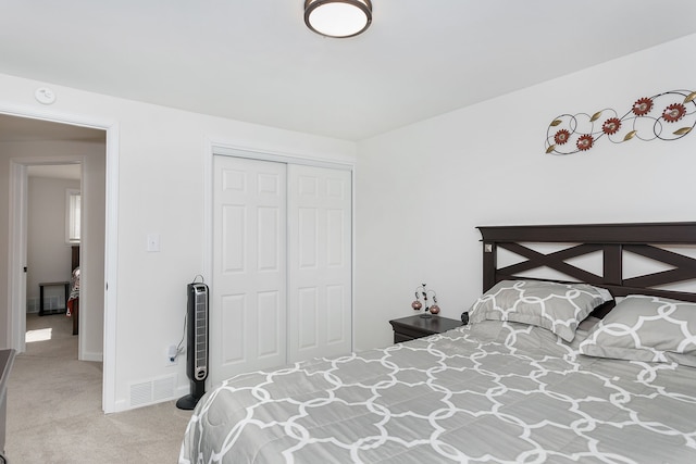 bedroom featuring a closet, carpet flooring, visible vents, and baseboards