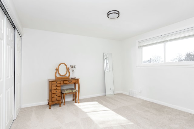 bedroom featuring visible vents, baseboards, a closet, and light colored carpet