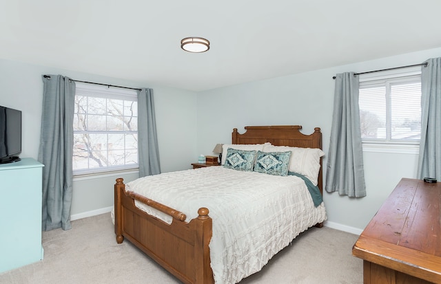 bedroom featuring light carpet and baseboards