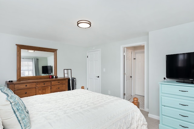 bedroom with baseboards and light colored carpet