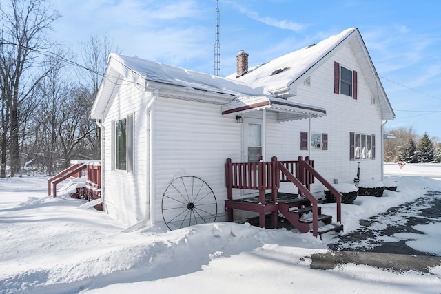 snow covered house with a chimney