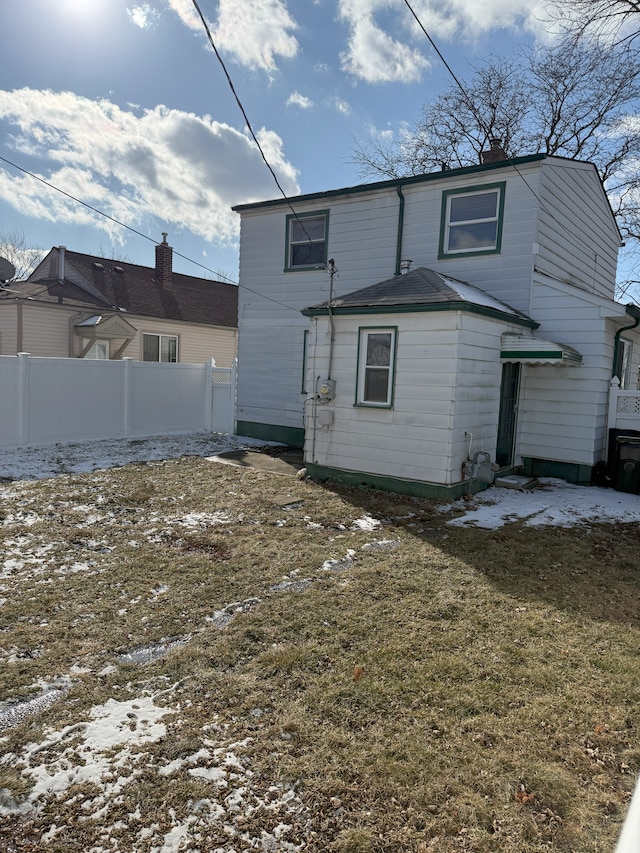 snow covered house with a yard