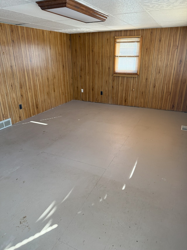 unfurnished room featuring wooden walls