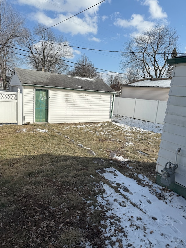 snow covered garage featuring a yard