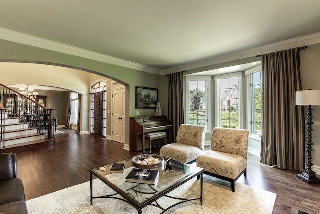 living room with ornamental molding, an inviting chandelier, and hardwood / wood-style floors