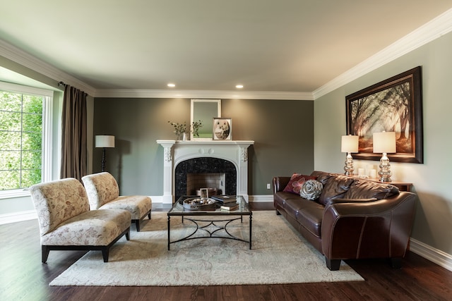 living room with a high end fireplace, hardwood / wood-style floors, and crown molding